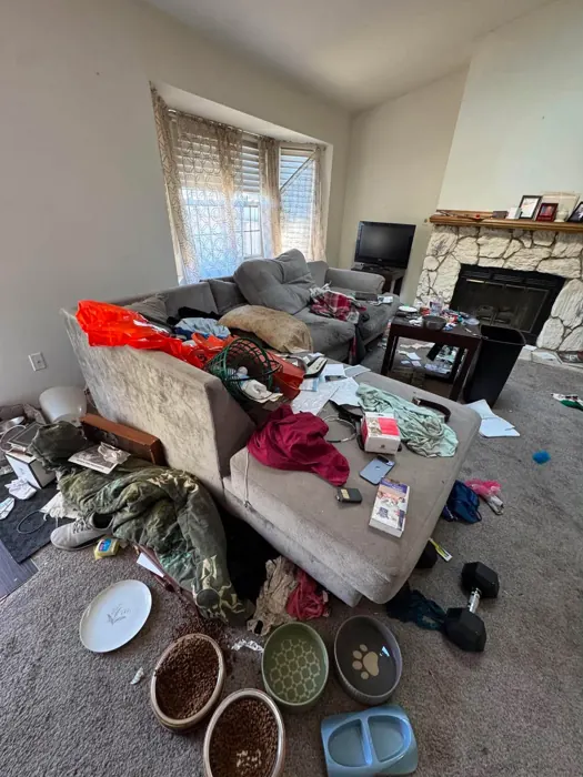 A living room full of clutter and belongings