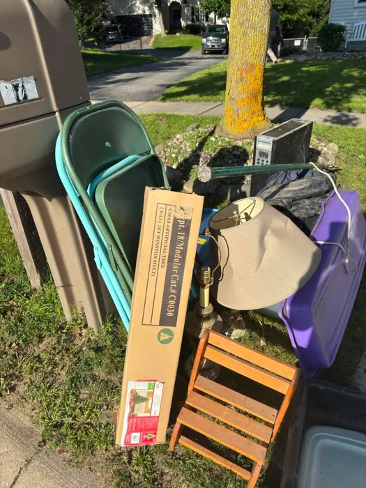 A curbside pile of household items and boxes