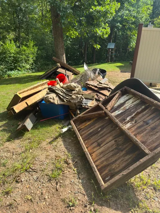 A yard with a pile of old lumber and debris