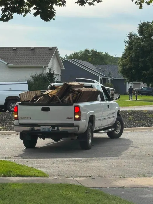 A pickup truck loaded with lumber and debris