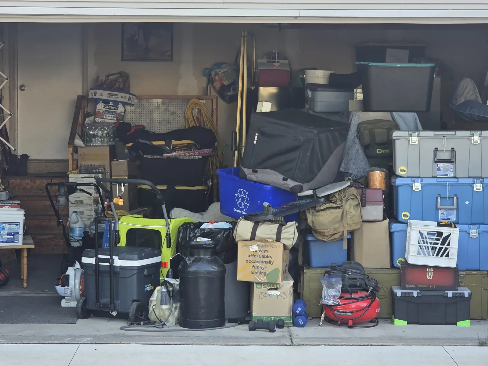 A garage packed with tools, bins and boxes, ready for a cleanout